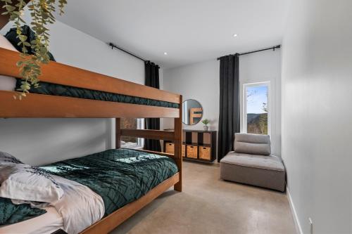 a bedroom with a bunk bed and a chair at Havre du Mont in Saint Come