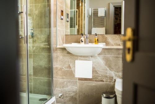 a bathroom with a sink and a shower at The Ayrlington Guesthouse in Bath