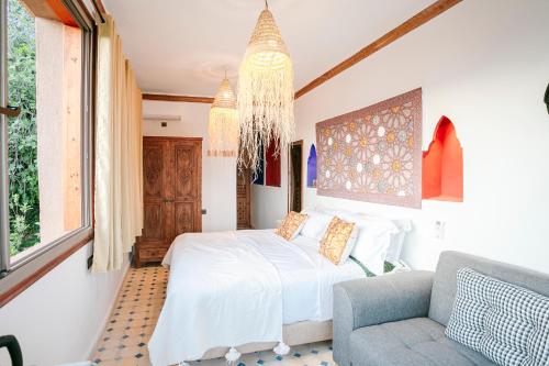 a bedroom with a bed and a chair and a chandelier at Atlas Smile Retreat in Ouirgane