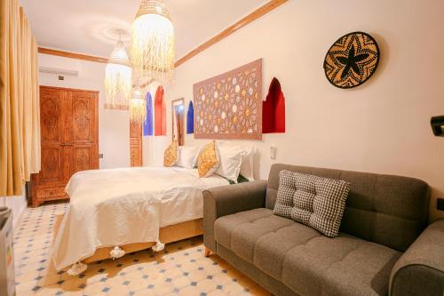 a bedroom with a bed and a couch and a clock at Atlas Smile Retreat in Ouirgane