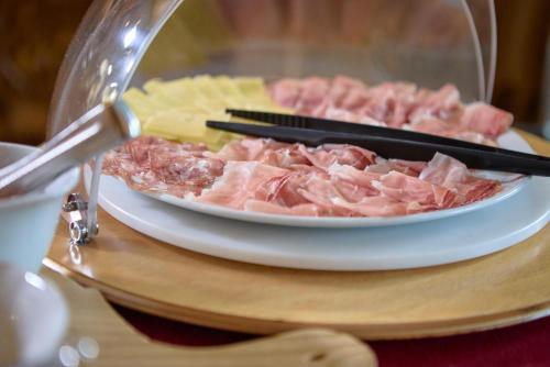 a plate of food with meat and chopsticks on a table at Hotel Garni dello Sportivo in Madonna di Campiglio