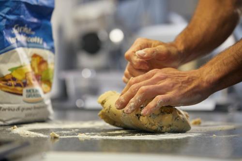 a man is kneading a dough with his hands at Hotel Garni dello Sportivo in Madonna di Campiglio