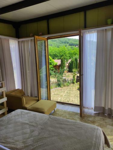 a bedroom with a bed and a window with a view at Milosev Konak in Aleksandrovac
