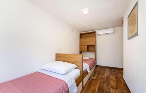 a small bedroom with two beds and wooden floors at 3 Bedroom Gorgeous Apartment In Seline in Seline