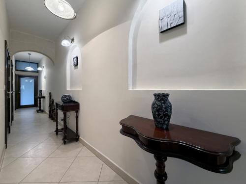 a hallway with a table with a vase on it at Traditional Maltese 3BD Apartment with Front & Back Balconies - Close to Gozo Ferry in Nadur