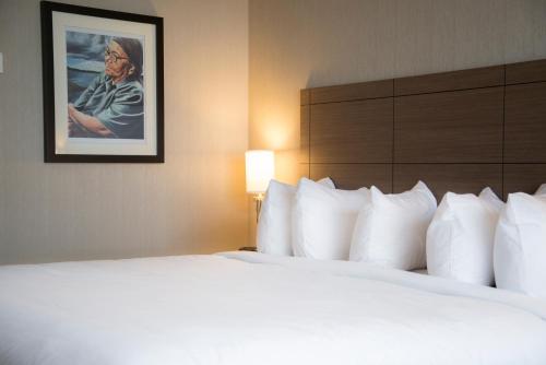 a hotel room with a bed and a picture on the wall at Quality Inn Sept-Iles in Sept-Îles