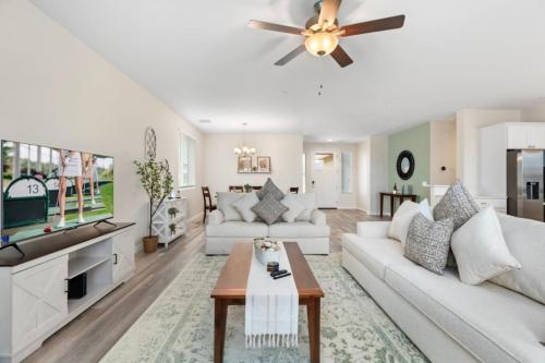 a living room with white furniture and a ceiling fan at Stylish Revival Retreat w Hot Tub and Fire Pit in Cottonwood