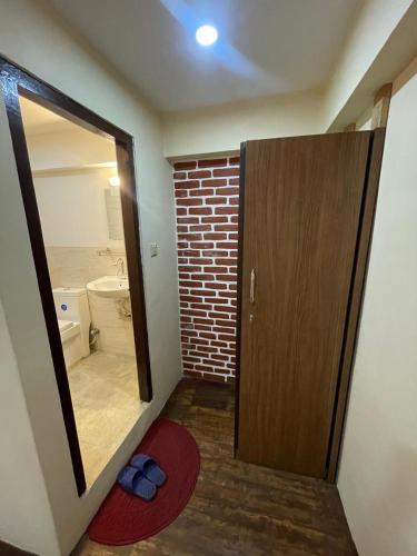 a bathroom with a mirror and a red rug at Cityview Guest House in Kathmandu
