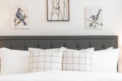 a bed with white pillows and three pictures on the wall at Stylish Revival Retreat w Hot Tub and Fire Pit in Cottonwood