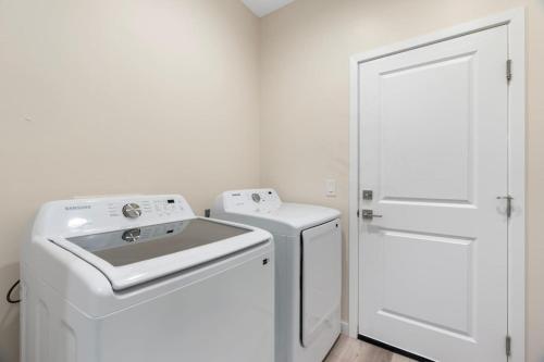 a white laundry room with a washer and dryer at Stylish Revival Retreat w Hot Tub and Fire Pit in Cottonwood