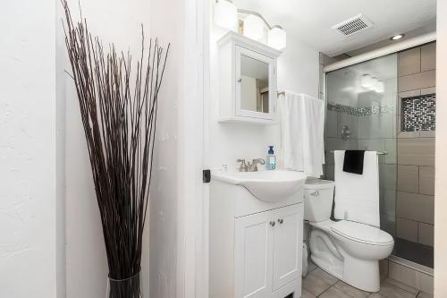 a white bathroom with a toilet and a sink at Cozy Millcreek Home SLC in Millcreek