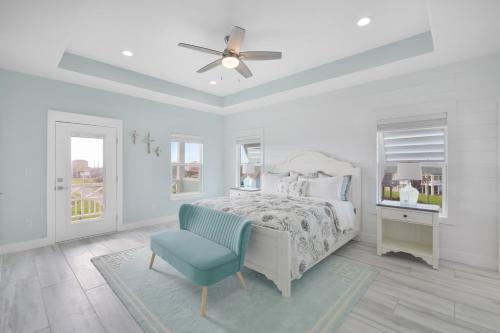 a white bedroom with a bed and a blue chair at Near Beach Large Home Sleeps 22 BBQ Soaking Tub in Bolivar Peninsula