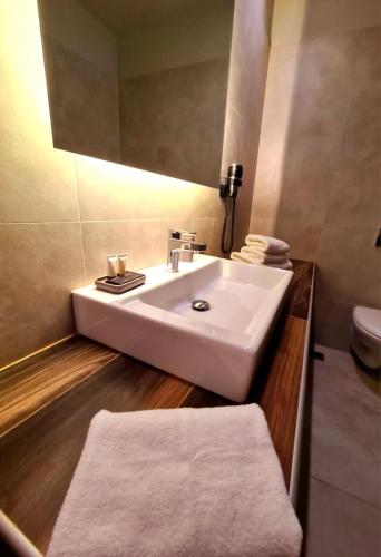 ピレウスにあるThe Georgeの白い洗面台とトイレのあるバスルーム