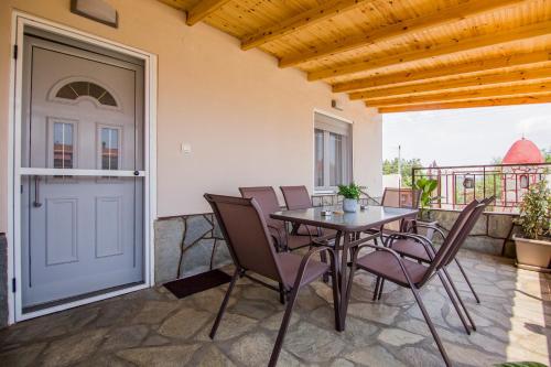 a patio with a table and chairs on a balcony at 4 seasons home Ofrinio in Ofrínion
