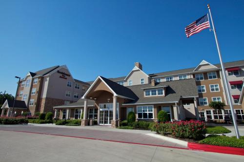 a building with an american flag in front of it at Residence Inn Bryan College Station in College Station