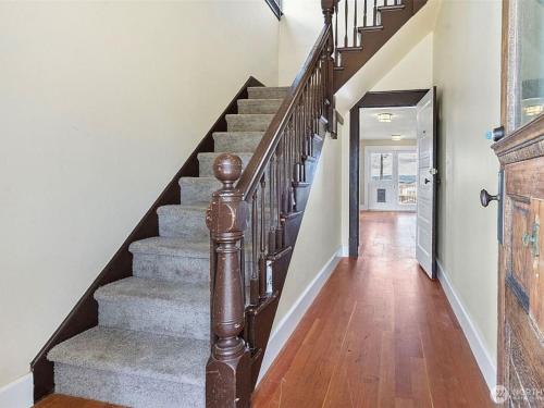 a staircase in a home with wooden floors and white walls at Bos Cozy Victorian Top Floor Duplex Unit with Puget Sound views in Tacoma