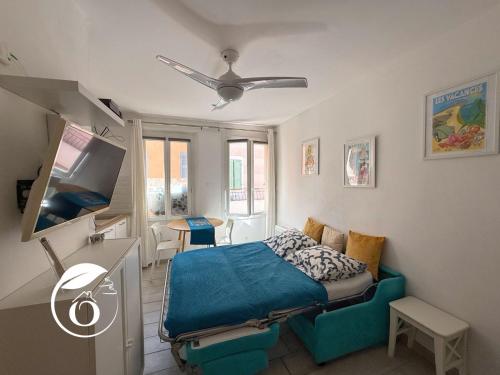 une chambre avec un lit, un canapé et une télévision dans l'établissement Superbe T1 bis sur le port et rue piétonne, à Sanary-sur-Mer