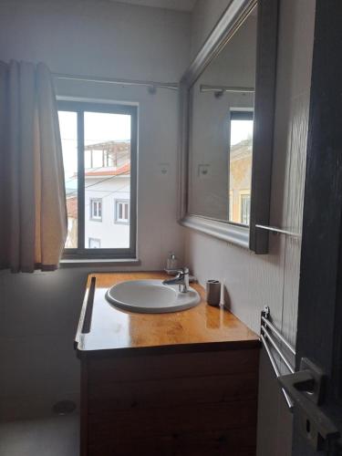 a bathroom with a sink and a mirror at Casa das Bonecas in São Martinho do Porto