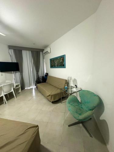 a living room with a couch and a chair at Apartamento Reserva do Sahy - Condomínio Aldeia dos Reis in Mangaratiba