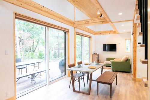 a living room with a table and a couch at Re to Li - りとり - 一棟貸しの宿 in Tsumagoi