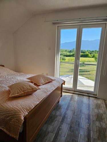 a bedroom with a bed and a large window at Villa Melek in Bihać