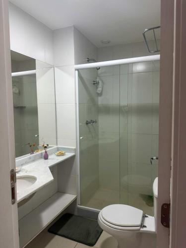 a bathroom with a shower and a toilet and a sink at Apartamento Reserva do Sahy - Condomínio Aldeia dos Reis in Mangaratiba