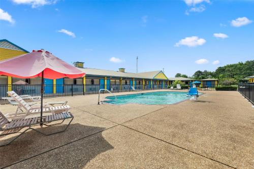 a swimming pool with two chairs and an umbrella at America's Best Value Inn and Suites in Aberdeen