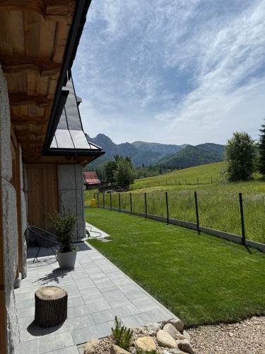 a porch with a view of a field and a fence at Kama Lama in Zakopane