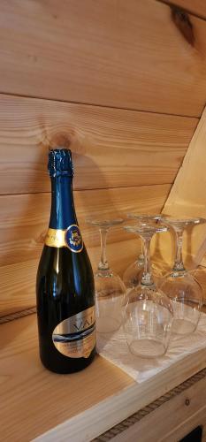 a bottle of beer on a table with glasses at Etno house Nomad in Šavnik