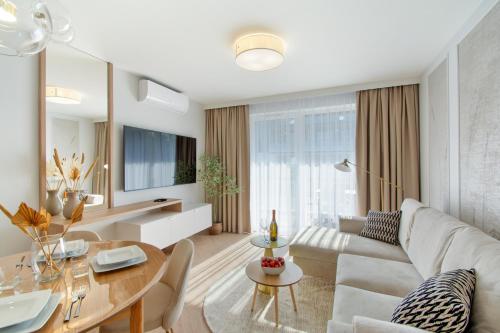 a living room with a couch and a table at Klif Apartamenty Posesja Plażowa in Grzybowo