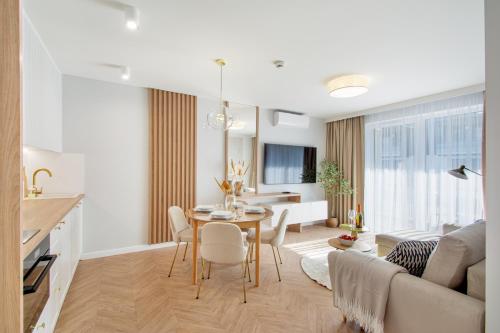 a kitchen and living room with a table and chairs at Klif Apartamenty Posesja Plażowa in Grzybowo