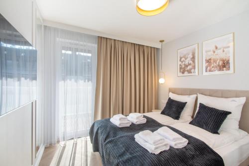 a bedroom with a bed with two towels on it at Klif Apartamenty Posesja Plażowa in Grzybowo