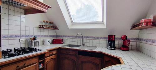 a kitchen with a sink and a window at Spacieuse maison familiale proche de la mer in Penvénan