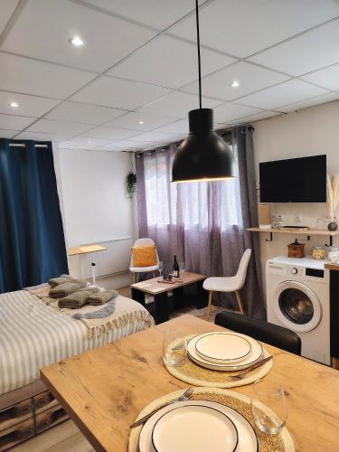 Cette chambre comprend une table, un lit et une cuisine. dans l'établissement Le Petit Choletais, à Cholet