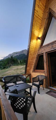 a patio with benches and tables on a cabin at Etno house Nomad in Šavnik