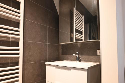 a bathroom with a sink and a mirror at Casa del Rops, luxury apartment, two bathrooms and roof terrace, near the beach in Cadzand