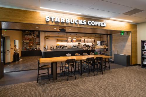 a starbucks coffee shop with a wooden table and chairs at Villa Graziadio Executive Center at Pepperdine University in Malibu