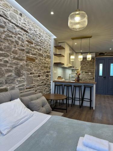 a kitchen and living room with a stone wall at Theros Retreat in Káspakas