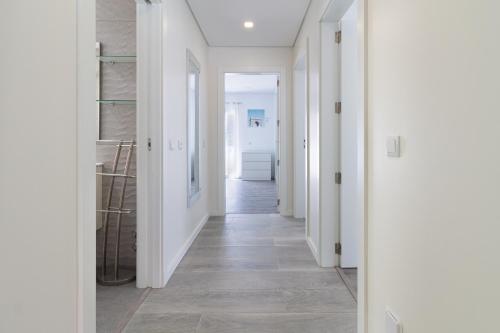 a hallway with white walls and wood floors at A Casa Choupal in Azeitao