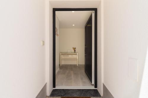 a hallway with a mirror in a white room at A Casa Choupal in Azeitao