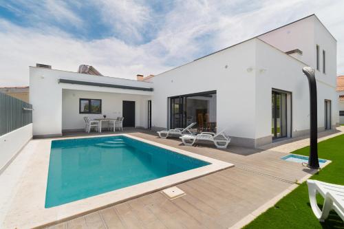 a swimming pool in the backyard of a house at A Casa Choupal in Azeitao