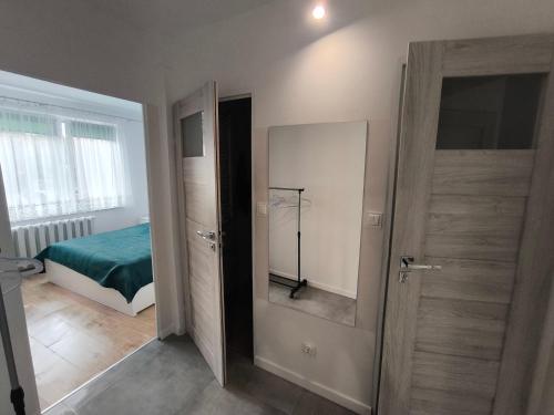 a bedroom with a bed and a door with a mirror at Apartament Lawendowy Piecki in Piecki