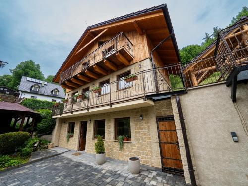 a building with two balconies on the side of it at Chaty pod Kamenným morom - Skalka in Vyhne