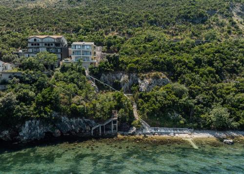 a house on a cliff next to the water at Njivice Coastal Oasis in Njivice