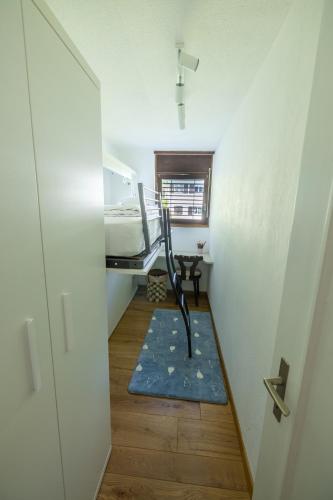 a small room with a bed and a blue rug at Mountain View - Trek, Bike, Ski, Lake in Flims