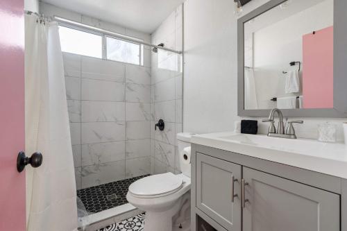 a bathroom with a toilet and a sink and a mirror at Family Pool House with games in National City