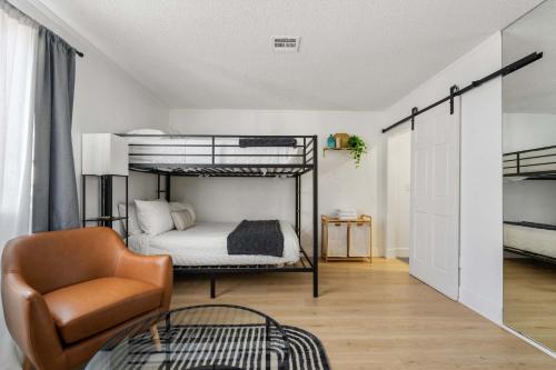 a bedroom with two bunk beds and a chair at Family Pool House with games in National City