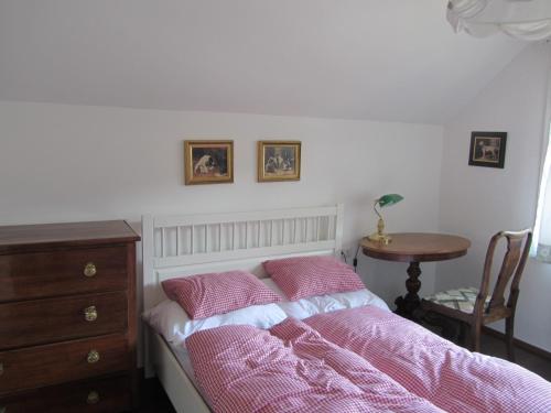 a bedroom with a bed with pink sheets and a table at Chalet "Hoamatl" in Haus im Ennstal