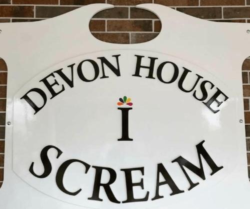 a sign for a demon house scam team on a building at Pearl of the City JAMAICA PEARL in Kingston