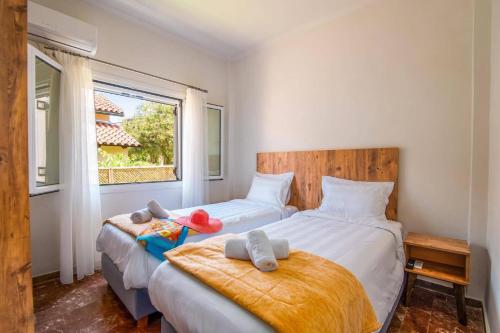 deux lits jumeaux dans une chambre avec fenêtre dans l'établissement Villa Mandola by Villa Plus, à Acharavi